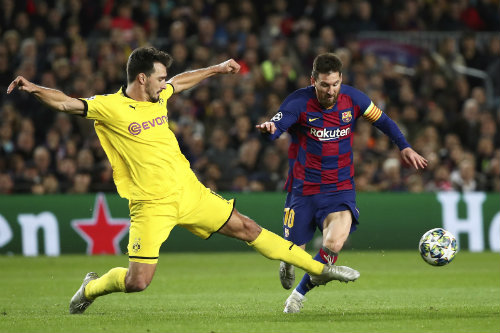 Lionel Messi intenta superar a Mats Humels durante un juego de UCL