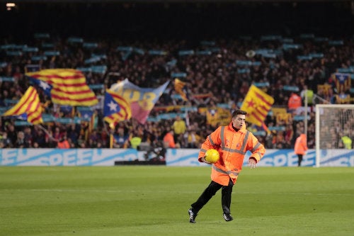Un elemento de seguridad recoge un balón amarillo en el Camp Nou