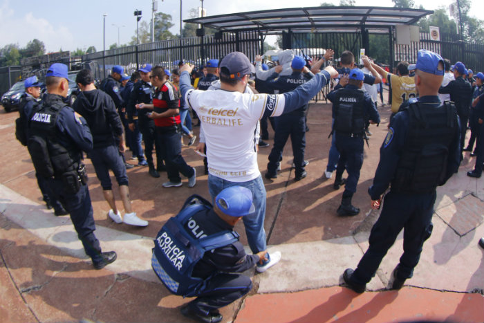 Policías revisan a fan previo a un partido de Pumas