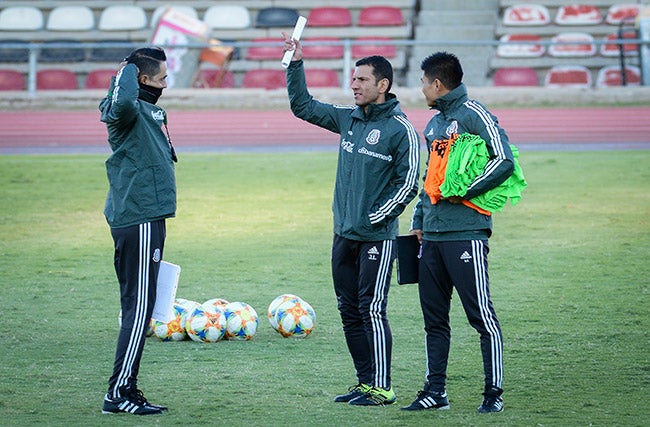 Jimmy Lozano conversa con su cuerpo técnico en una práctica