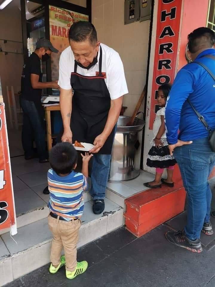 Taquero entregando comida a un niño