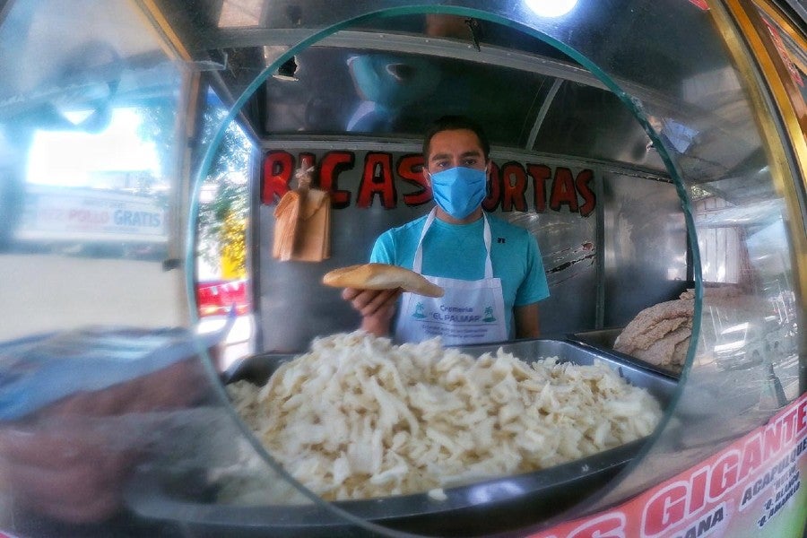 Persona trabajando en local de comida con cubrebocas