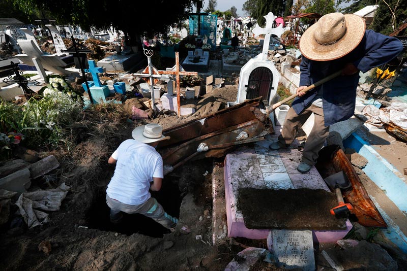 Trabajadores de un cementerio entierran a una persona