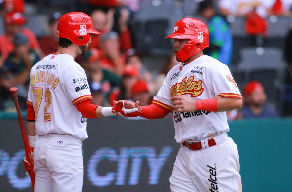 Jugadores de los Diablos Rojos del México celebran una carrera