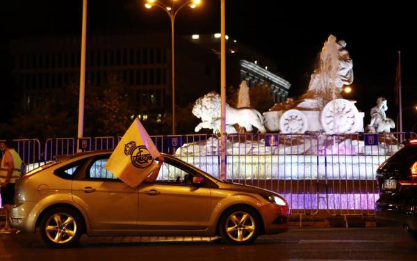 Automovilistas ondean banderas del Real Madrid en la Cibeles