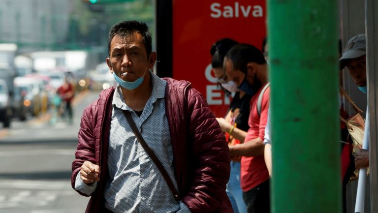 Habitante de la Ciudad de México con cubrebocas en parada de camión