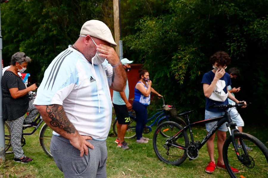 Personas desconsoladas a las afueras de la residencial de Maradona