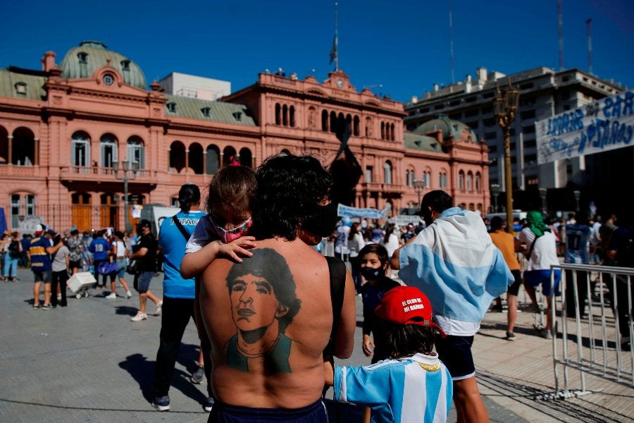 La espalda de una persona con el tatuaje del rostro de Maradona