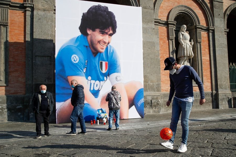 Aficionados observando una imagen de Maradona en Nápoles