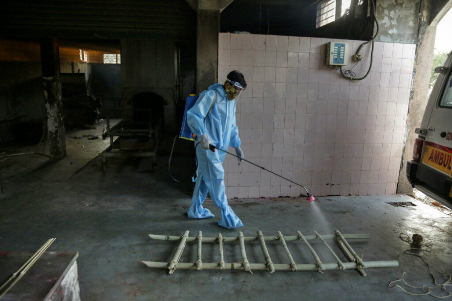 Trabajador desinfectando área de crematorio en India