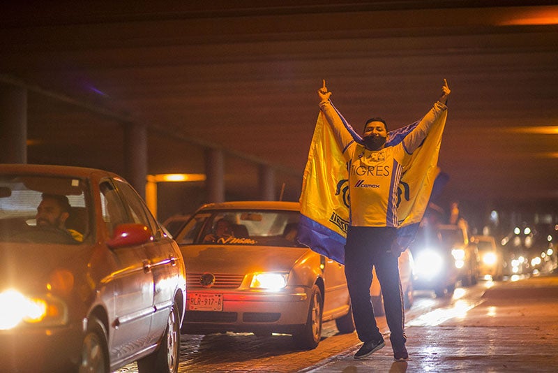 Aficionado celebra con una bandera de Tigres 