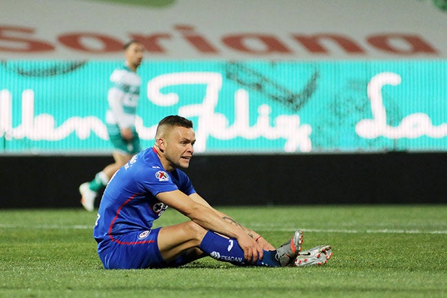 Cabecita, sentado en el campo durante un juego del Cruz Azul