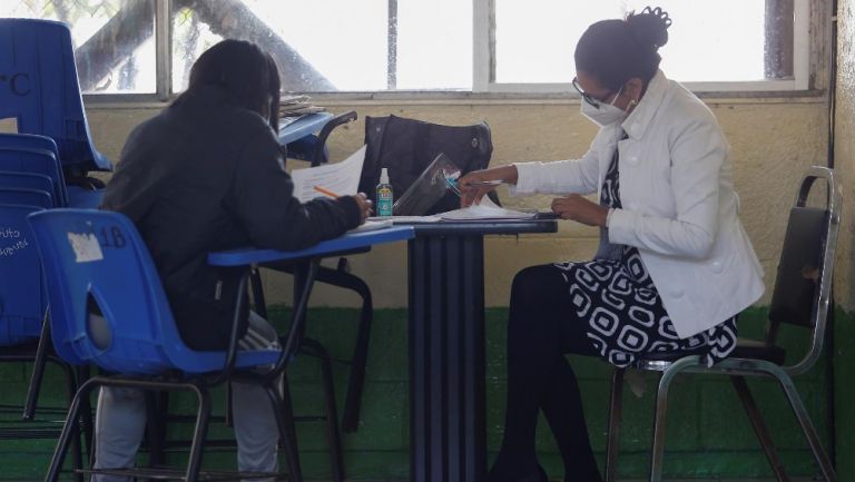 Estudiante con maestra en escuela de la Ciudad de México