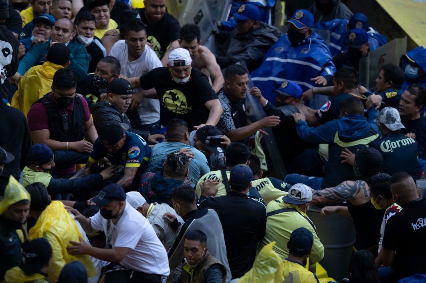 Aficionados del América peleando en la tribuna del Estadio Azteca