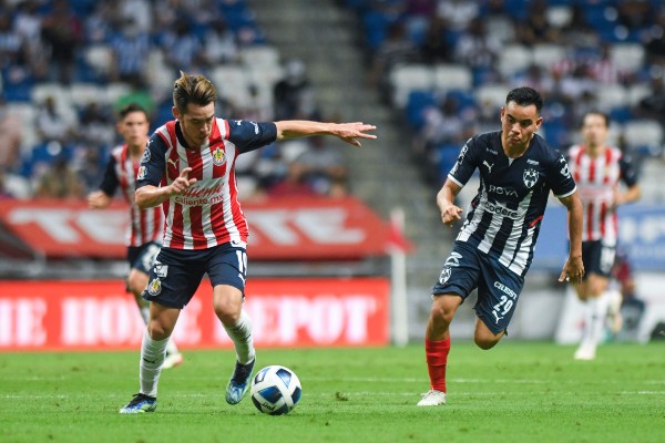 Jesús Ángulo de Chivas disputa balón contra Carlos Rodríguez de Rayados