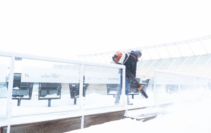 Empleados trabajan para retirar la nieve de las tribunas