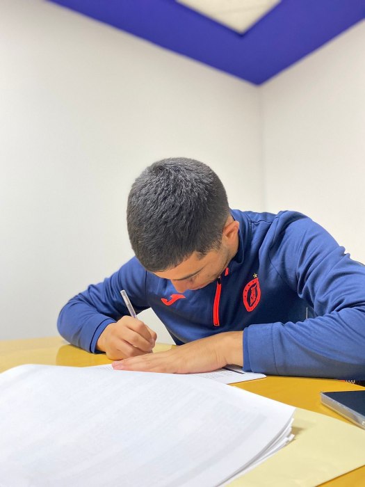 Erik Lira firmando contrato con Cruz Azul