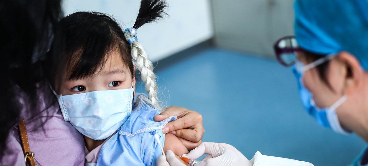 Niña es vacunada en un centro médico