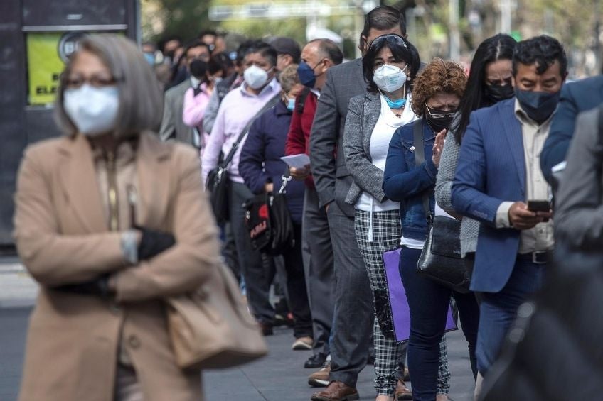 Personas esperando para acceder a un edificio