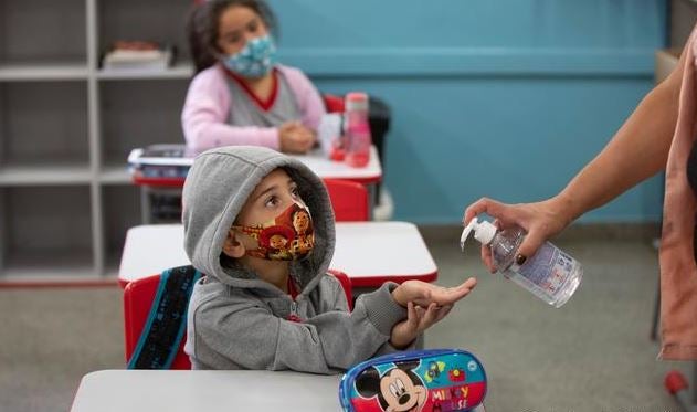 Niño recibe gel en regreso a clases