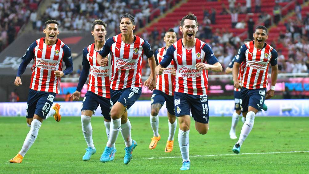 Jugadores de Chivas celebrando gol durante partido de Liga MX