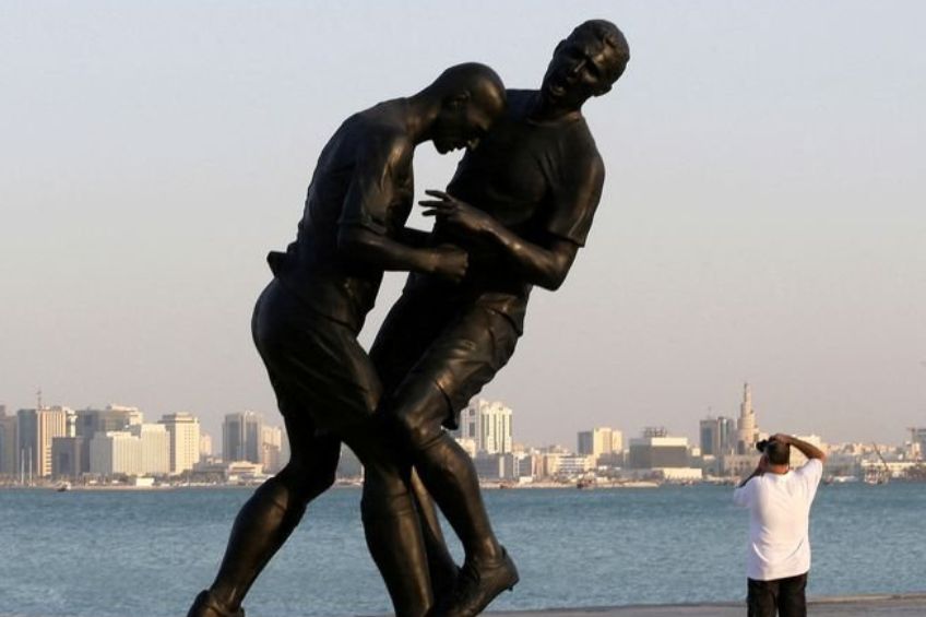 Persona tomándole foto a la estatua de Zidane y Materazzi
