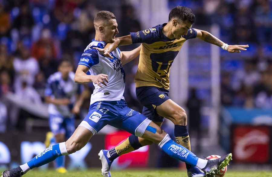 Juan Dinenno pelea el balón con Lucas Maia en un Pubela vs Pumas