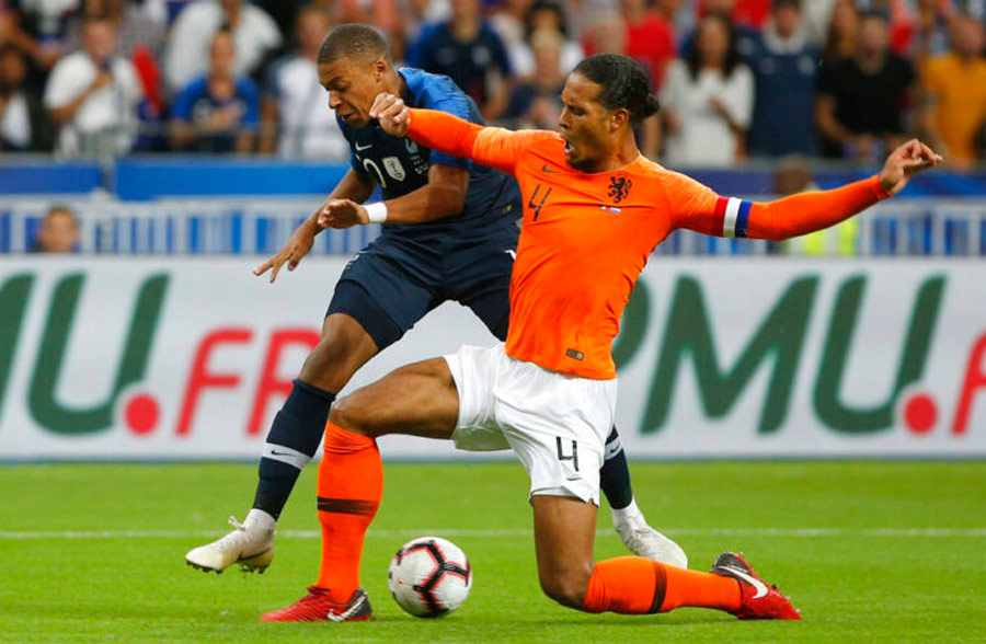 Virgil van Dijk disputa el balón con Mbappé