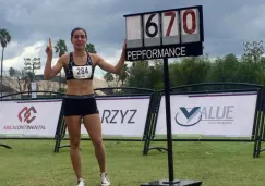 Yvonne Treviño posa al lado de la marca que impuso en el Campeonato Nacional de Atletismo