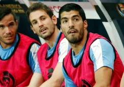 Luis Suárez sentado en la banca junto a sus compañeros de la selección de Uruguay