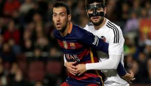 Busquets es sujetado por un jugador del Valencia