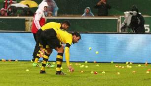 Jugadores, sacando las pelotas de tenis del campo