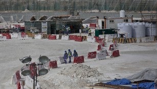 Inmigrantes caminan entre una zona de construcción del estadio Al-Wakra para Qatar 2022