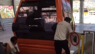 Dos empleados del Municipio de Ecatepec intentan destrabar una cabina del 'Mexicable'