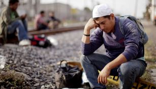 Un migrante se sienta a meditar al lado de las vías del tren