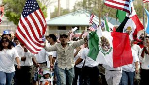 Migrantes portan banderas de Estados Unidos y México 