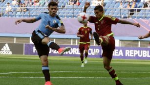 Jugadores de Uruguay y Venezuela disputan el balón