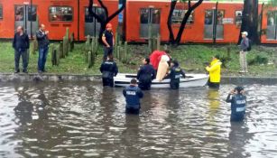 Un grupo de policías ayuda a personas a salir de la inundación en Insurgentes Norte
