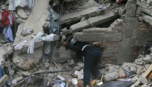 Un rescatista intenta ubicar a personas atrapadas por el terremoto