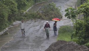 Gente camina por una carretera deslavada de Costa Rica