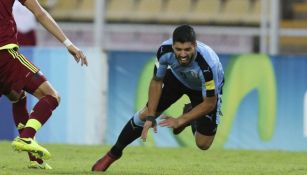 Luis Suárez cae al césped durante un juego con Uruaguay