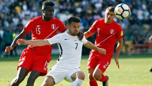 Jugadores de Perú ejercen presión sobre un rival de Nueva Zelanda