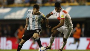 Wílder Cartagena disputa un balón con Messi en la Eliminatorias de Conmebol