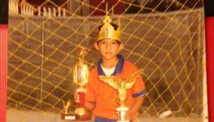 Alan Pulido carga un trofeo de niño