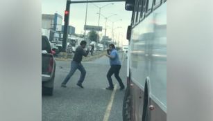 Dos personas pelean a media calle entre el tráfico