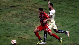 Duilio Guillermo Tejada conduce el balón frente a la marca americanista