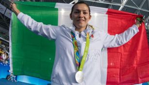 María Espinoza sostiene con alegría la bandera de México