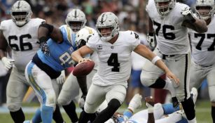 Derek Carr intentando escapar de la defensiva de los Chargers