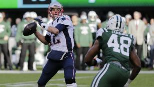 Tom Brady lanza un pase ante la vista de Jordan Jenkins