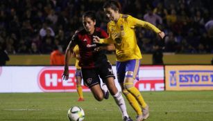 Jugadoras de Atlas y Tigres disputando el balón 